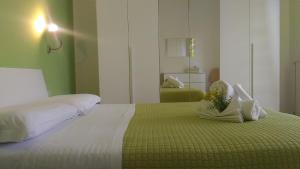 a bedroom with a large bed with a green blanket at Riviera Apartments in Pietra Ligure
