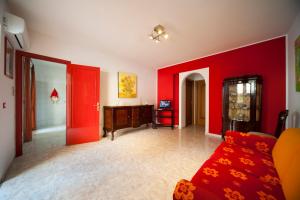 a living room with red walls and a red couch at Colapesce Appartamento in Santa Teresa di Riva