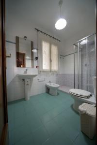 a bathroom with two sinks and a toilet and a shower at Colapesce Appartamento in Santa Teresa di Riva