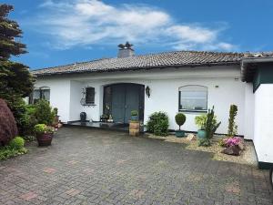 a white house with a brick driveway in front of it at Bed and Breakfast am Höhenweg in Warstein