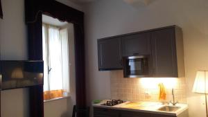 a kitchen with black cabinets and a sink and a window at Casa Maria e Casa Cristina in Orvieto +57 photos