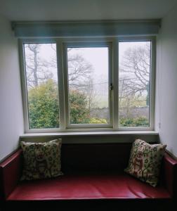 a window seat with two pillows in front of it at The Hollies in Adare