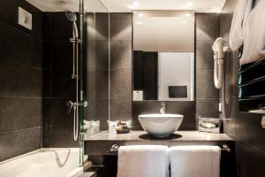 un bagno con lavandino e vasca da bagno di Hôtel Cloitre Saint Louis Avignon ad Avignone