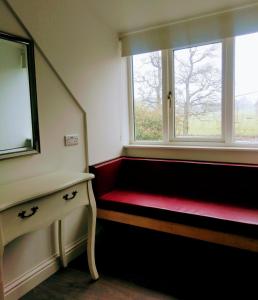 Pokój z czerwoną ławką i oknem w obiekcie The Hollies w mieście Adare