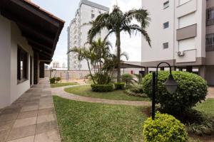 un patio con un edificio, una palmera y un semáforo en Maravilhoso apartamento 3 quartos perto PUC, en Porto Alegre