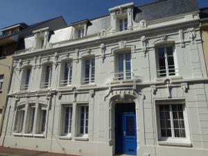 um edifício branco com uma porta azul em B&B A La Maison Blanche em Fécamp