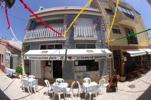 restauracja ze stołami i krzesłami przed budynkiem w obiekcie GuestHouse O Cuco w mieście Praia de Mira
