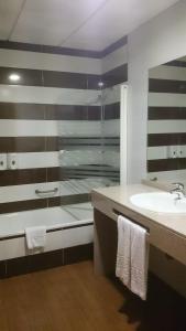a bathroom with a glass shower and a sink at Hotel Romero Merida in Merida