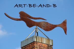 a metal sculpture of an eagle on top of a chimney at Art-be-and-b Appartement -Studios in Riegel am Kaiserstuhl