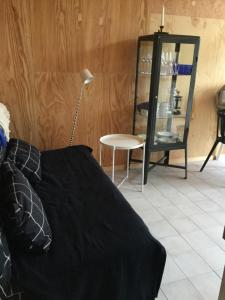 een slaapkamer met een bed, een lamp en een stoel bij Båstad Ateljehus in Båstad