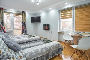 2 camas en una habitación con mesa y escritorio en Apartamenty Lux Relax, en Białystok