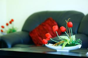 a bowl of red flowers on a table at Muscat International Hotel in Muscat