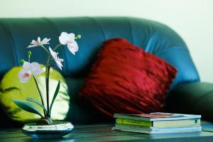 a table with books and flowers on a couch at Muscat International Hotel in Muscat