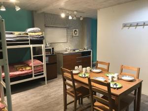a room with a table and chairs and a bunk bed at AK202 Guest house AKASAKA in Fukuoka