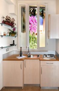 une cuisine avec un évier et une fenêtre dans l'établissement appartamentini5terre, à Monterosso al Mare