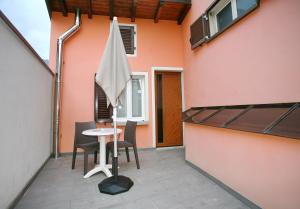 eine Terrasse mit einem Tisch und Stühlen neben einem Gebäude in der Unterkunft B&B 21 in Cannobio