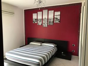 łóżko w pokoju z czerwoną ścianą w obiekcie Dolce Sogno w mieście Alghero