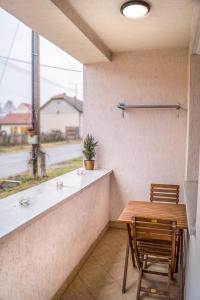 a table and chairs in a room with a window at Oázis Apartmanok in Mórahalom