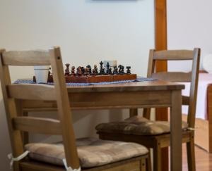 ein Schachbrett auf einem Tisch mit zwei Stühlen in der Unterkunft Oázis Apartmanok in Mórahalom
