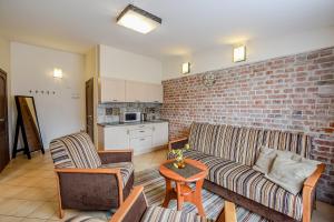 a living room with a couch and a brick wall at Kubu Apartment in Klaipėda