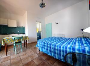 a bedroom with a bed and a table and a greenboard at Casa Balena Bianca in Lacona