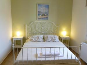 a bedroom with a white bed with two night stands at Ktima Pyroessa Apartments - Yellow Apartment in Thános +4 photos