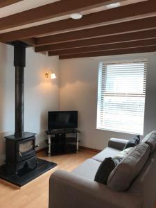 a living room with a couch and a wood stove at Snowdonia End Terrace in Caernarfon