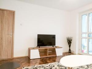 Biały salon z telewizorem i stołem w obiekcie Promenada Apartment w Konstancy