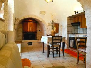 een keuken met een tafel en stoelen in een kamer bij I Trulli degli Ulivi in Locorotondo