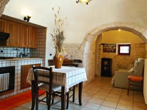 a kitchen with a table with a vase on it at I Trulli degli Ulivi in Locorotondo