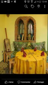 een kamer met een tafel met een geel tafelkleed bij Dar Aldea in Chefchaouene