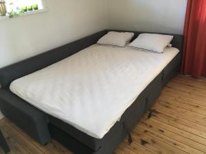 uma cama com duas almofadas num quarto em Tråvad Nybo Lilla huset em Tråvad