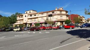 a street with cars parked in front of a building at Hostal Restaurante Los Bronces in Riópar