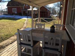 een veranda met een tafel en stoelen op een huis bij Tråvad Nybo Lilla huset in Tråvad