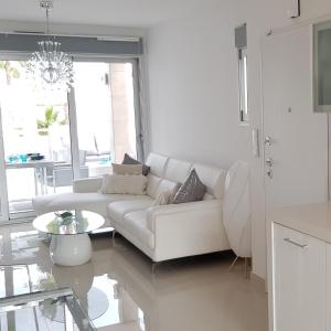 a white living room with a white couch and a table at Sensación Azul in Torrevieja
