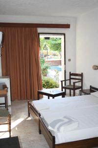 a bedroom with two beds and a large window at Oasis Hotel Bungalows Rhodes- All Inclusive in Afantou