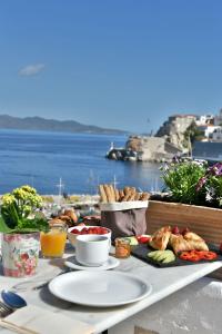una mesa con comida y vistas al océano en Douskos Port House en Hydra