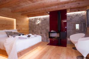 una camera con letto e parete in pietra di Chalet Nel Doch Villa Cheia a Canal San Bovo