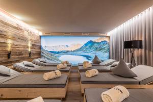 a room with a large screen with a bunch of beds at Hotel Schönblick in Maranza