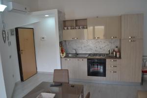 cocina con mesa y fogones horno superior en Planet apartments 2, en Montalbano Ionico