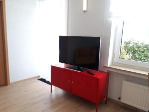 un televisor en una cómoda roja en una habitación en FeWo Lilly, en Willingen