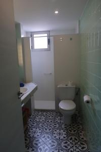 a bathroom with a white toilet and a sink at Apartamentos Guillem in Playa de Miramar