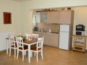 a kitchen with a table and chairs and a white refrigerator at Ktima Pyroessa Blue Suite in Thános