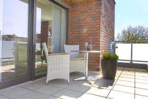 eine Terrasse mit Tisch und Stühlen auf einem Balkon in der Unterkunft Refugium 1 in Emsdetten