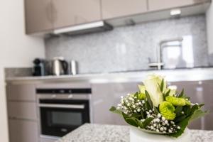 eine Küche mit einer Vase mit Blumen auf einer Theke in der Unterkunft Refugium 1 in Emsdetten