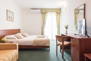 a hotel room with a bed and a desk and a couch at Hotel Krilo in Podstrana