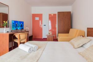 um quarto de hotel com duas camas, uma secretária e um computador em Hotel Krilo em Podstrana