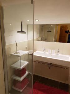 un baño con lavabo y espejo en Haus Kathrin, en Kaprun