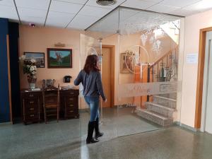 una mujer caminando a través de una ventana de cristal en un edificio en Hotel Don Pelayo, en L'Arboç