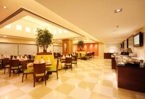a dining room with tables and chairs in a restaurant at Aditya Hometel in Hyderabad